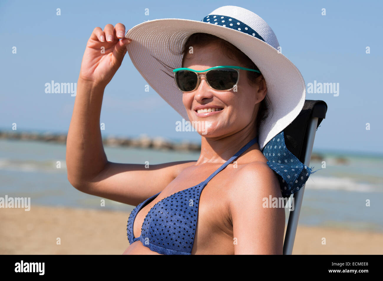 Woman with bikini, sunglasses and sun hat on the beach, Adriatic, Senigallia, Province of Ancona, Marche, Italy Stock Photo