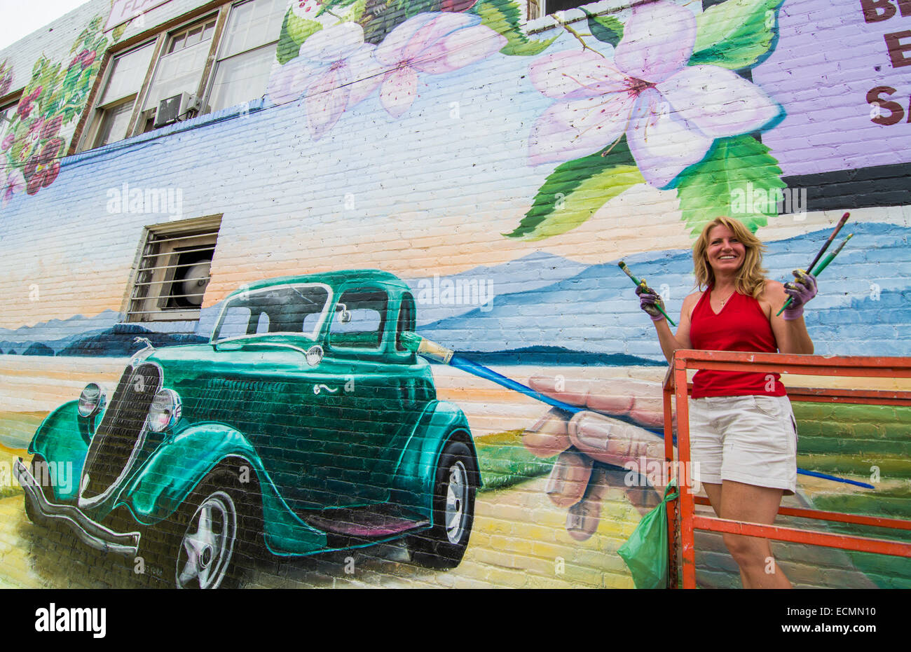 Polson Montana artist painting large mural for Flathead Cherry Council