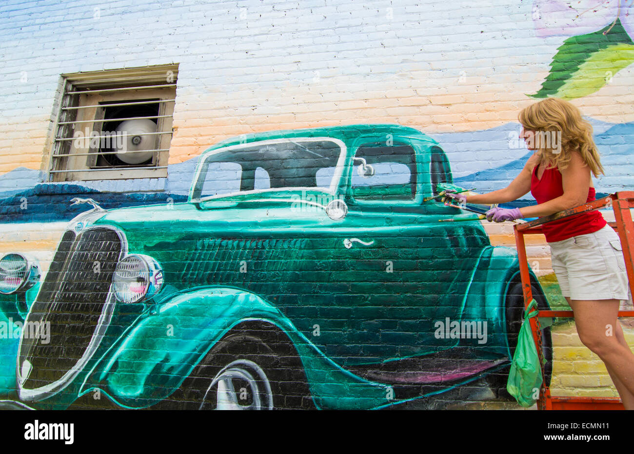 Polson Montana artist painting large mural for Flathead Cherry Council