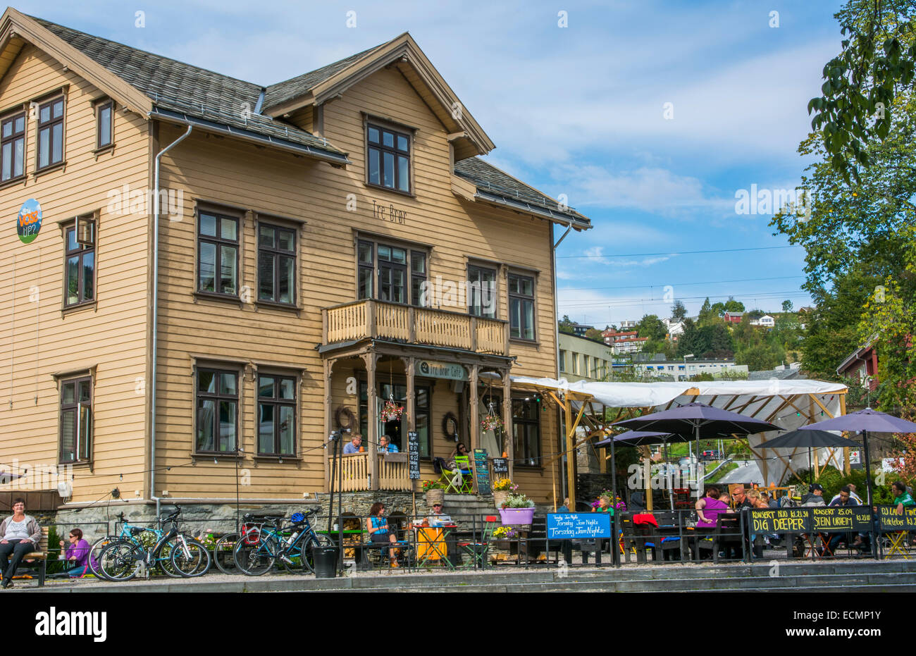 Voss Norway landmark Tre Bror Cafe wooden buildiung with people relaxing outside in sunshine on