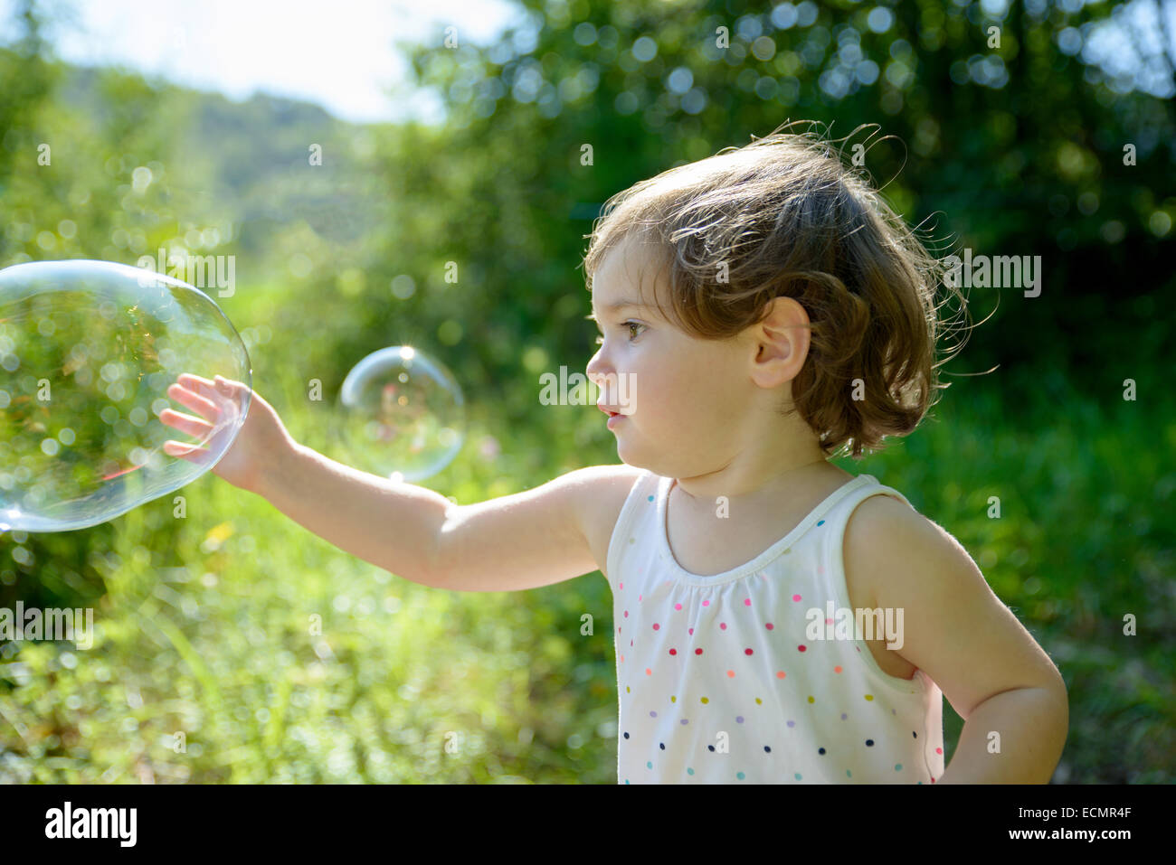a little girl playing with soap bubbles in nature Stock Photo - Alamy