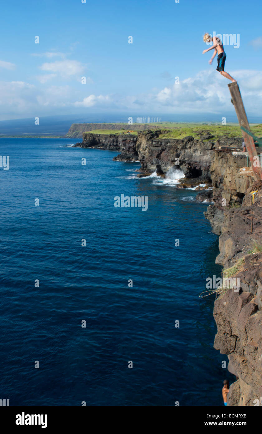South Point Hawaii Big Island cliff pole young man diving intp water