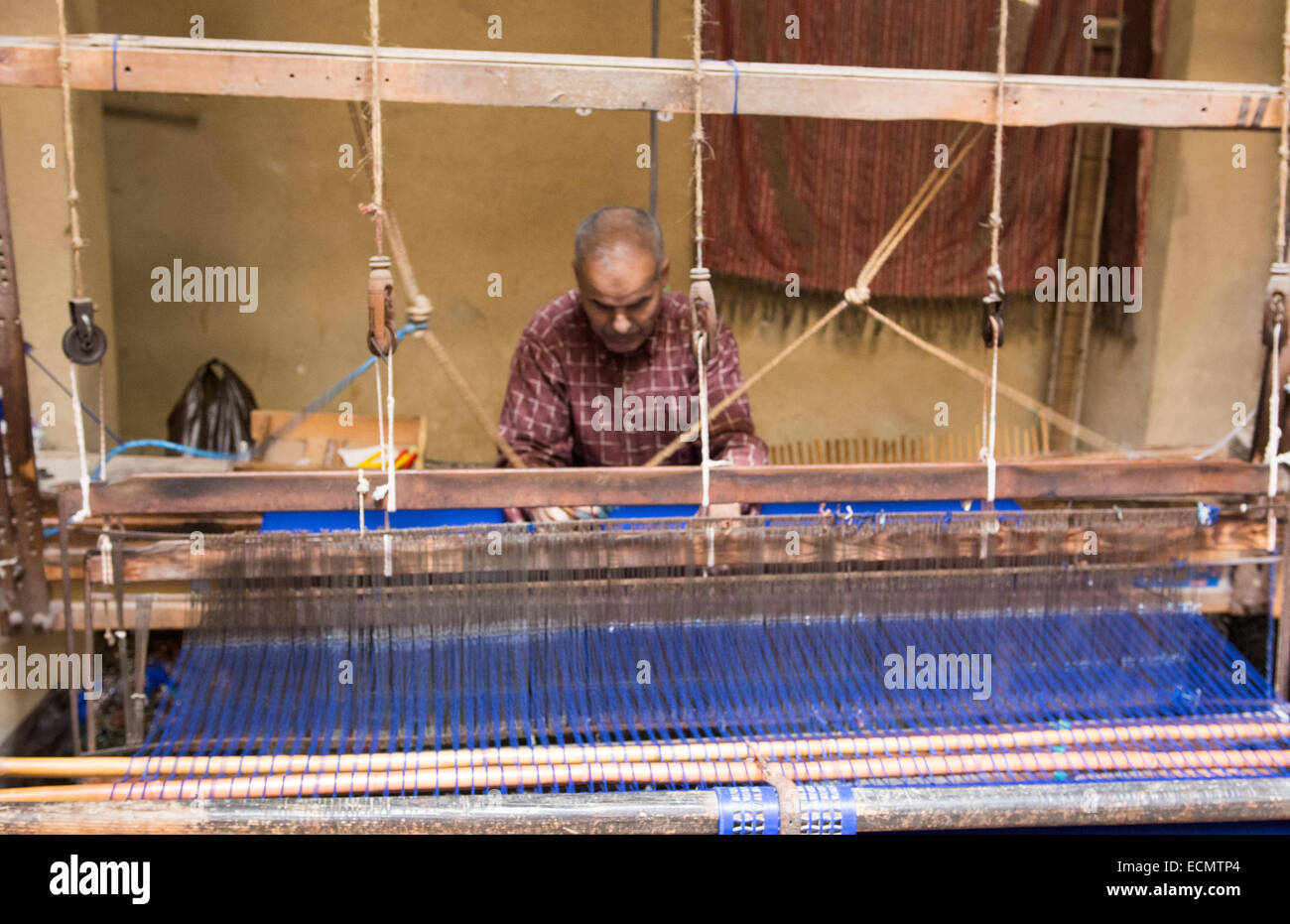 Morocco Fez silk factory man working on loom machine working with blue silk Stock Photo