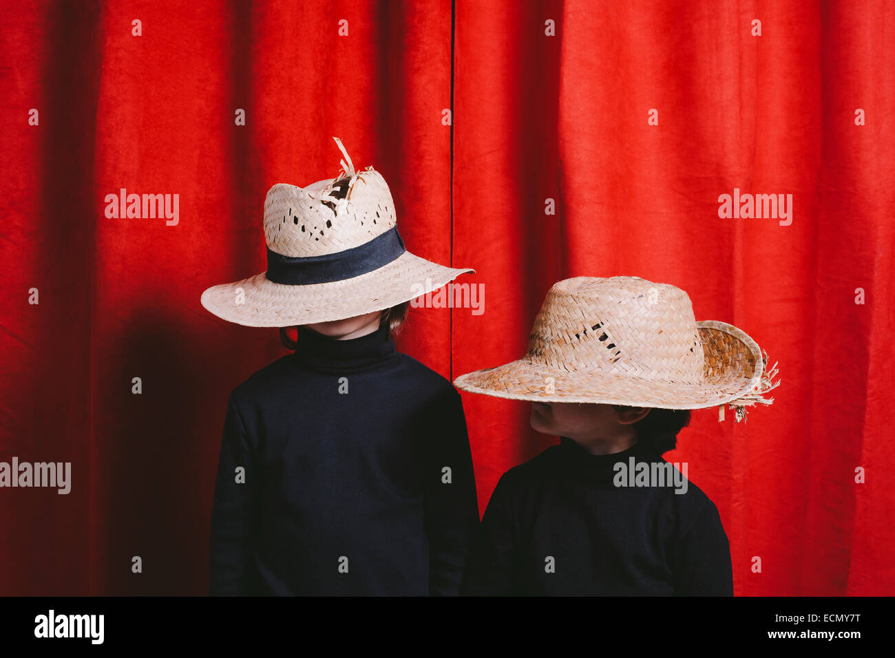 Studio portrait of two boys wearing black clothes and a straw hut Stock Photo