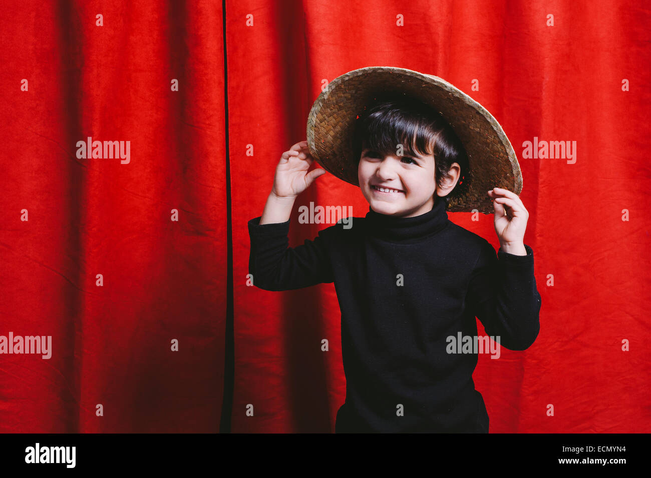 Three year old boy wearing black clothes and a straw hut Stock Photo