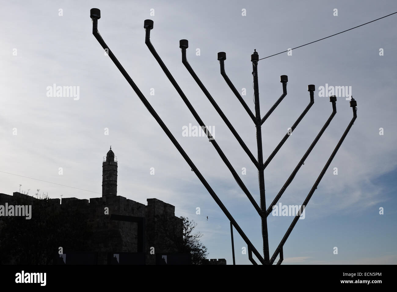 A 'chanukkiah', an eight-branched menorah or candelabrum, is set below the early Muslim period round tower, known as the Tower of David, in preparation for Hanukkah, a Jewish festival commemorating the 164 BCE rededication of the Second Temple in Jerusalem after its desecration by the ruling Seleucid (Syrian Greek) Kingdom, under Antiochus IV. Stock Photo