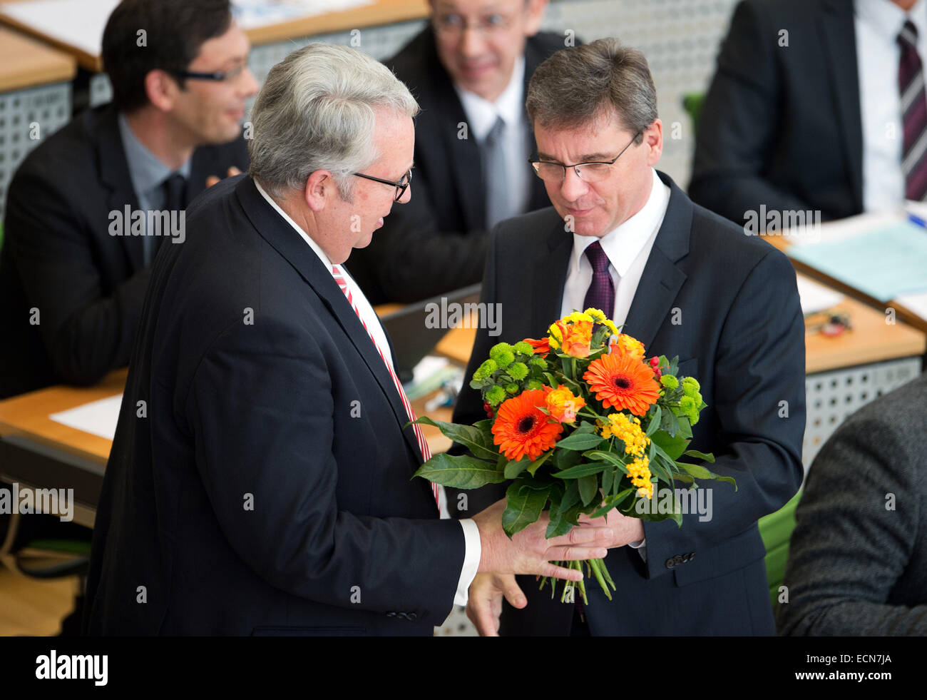 Dresden, Germany. 17th Dec, 2014. The chairman of the regional parliamentary faction of the CDU, Frank Kupfer (R), hands a buquet of flowers to Saxony's new commissioner for foreigners in Saxony, Geert Mackenroth (CDU), after his election at Saxony's state parliament in Dresden, Germany, 17 December 2014. Photo: Arno Burgi/dpa/Alamy Live News Stock Photo