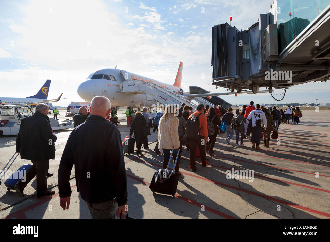 Passengers walking to board Easyjet aircraft under jet bridge Stock Photo