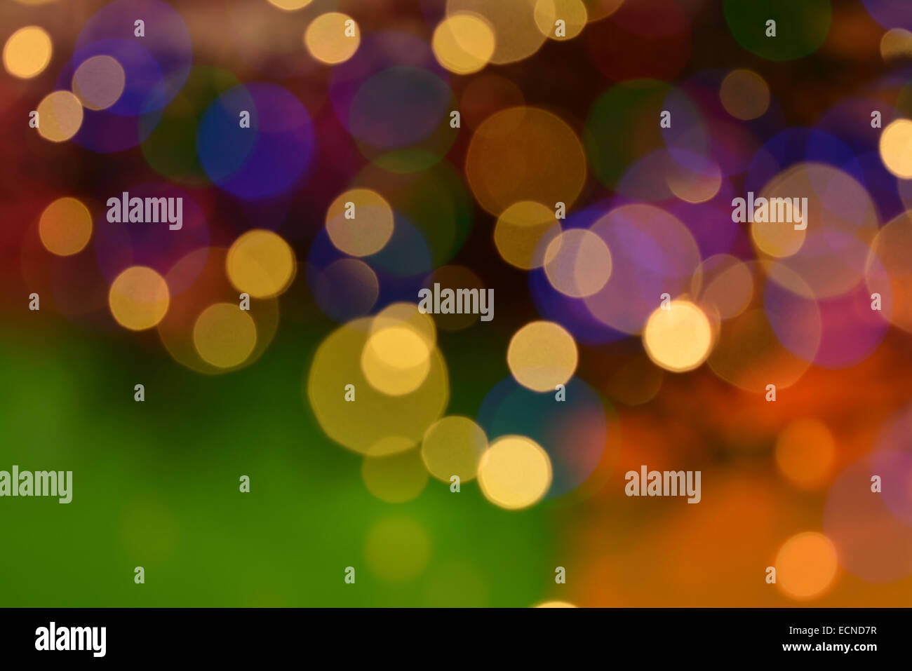Blurred 'New Year' Christmas tree lights background in warm colours of gold green purple and orange Stock Photo