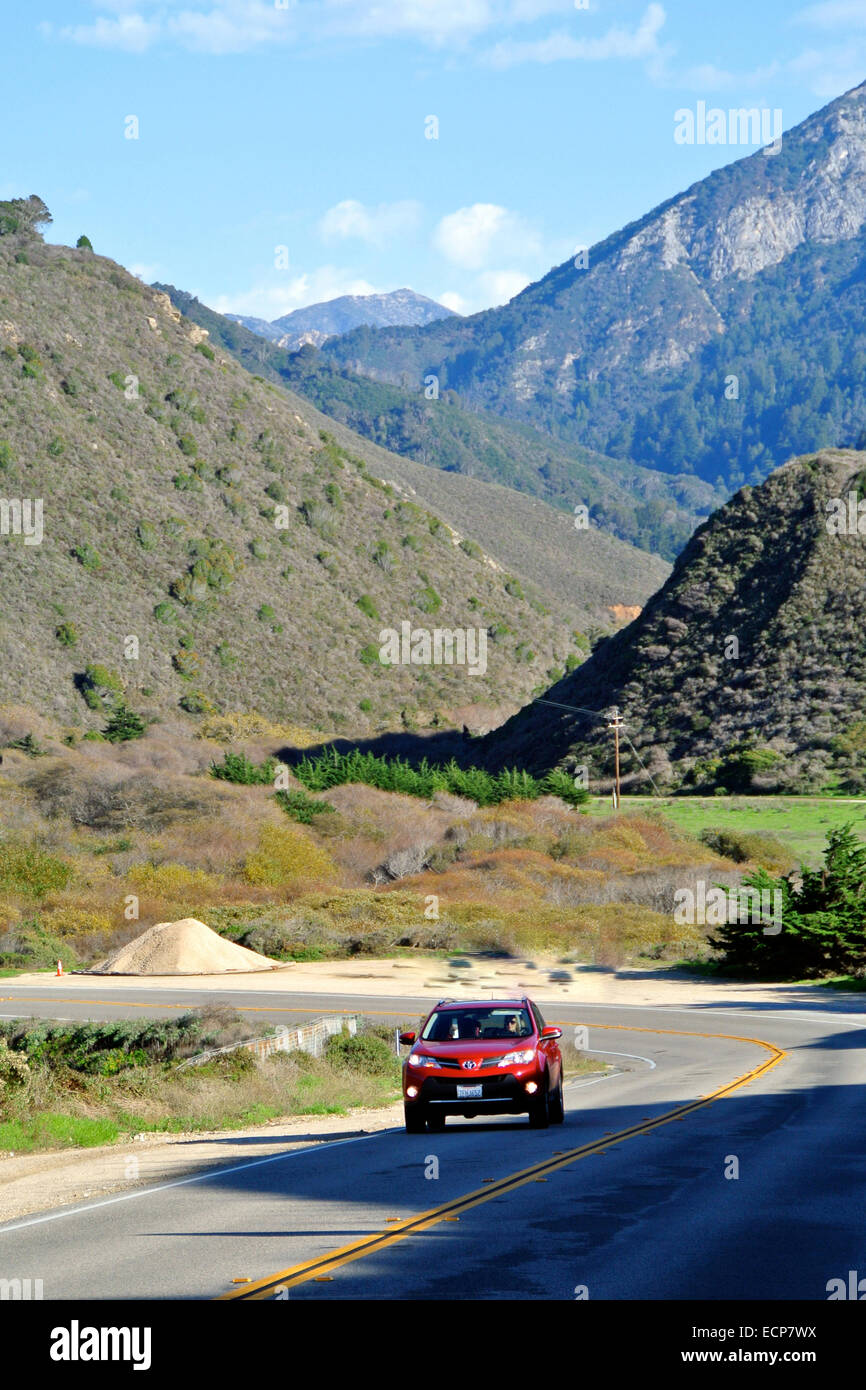 red car travels on highway 1 in the Big Sur area of Monterey County California Stock Photo