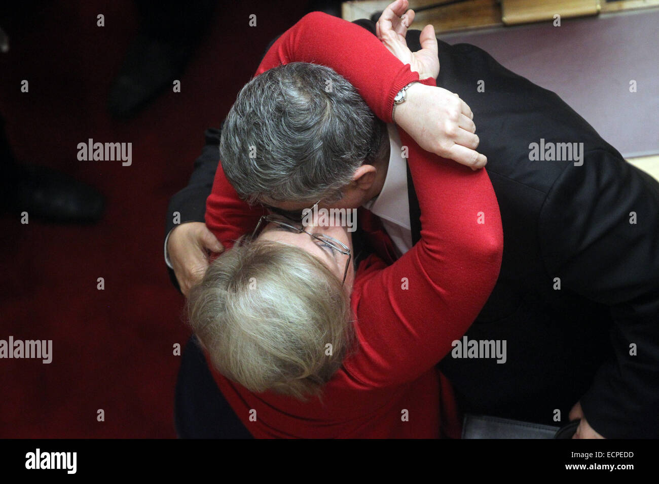 Athens, Greece. 17th Dec, 2014. The leader of the far-right political party Golden Dawn Nikos Michaloliakos (R), is kissed by his wife and lawmaker Eleni Zaroulia during the first round of voting to elect a new president of the Hellenic Republic at the Parliament in Athens, Greece, Dec. 17, 2014. Greek parliament failed on Wednesday to elect a new President of the Hellenic Republic in the televised first round of the roll-call vote on Wednesday evening. Credit:  Marios Lolos/Xinhua/Alamy Live News Stock Photo