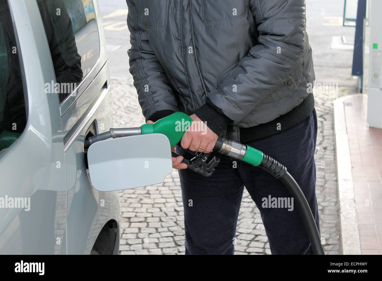 Man inserting nozzle in fuel cap of a car Stock Photo