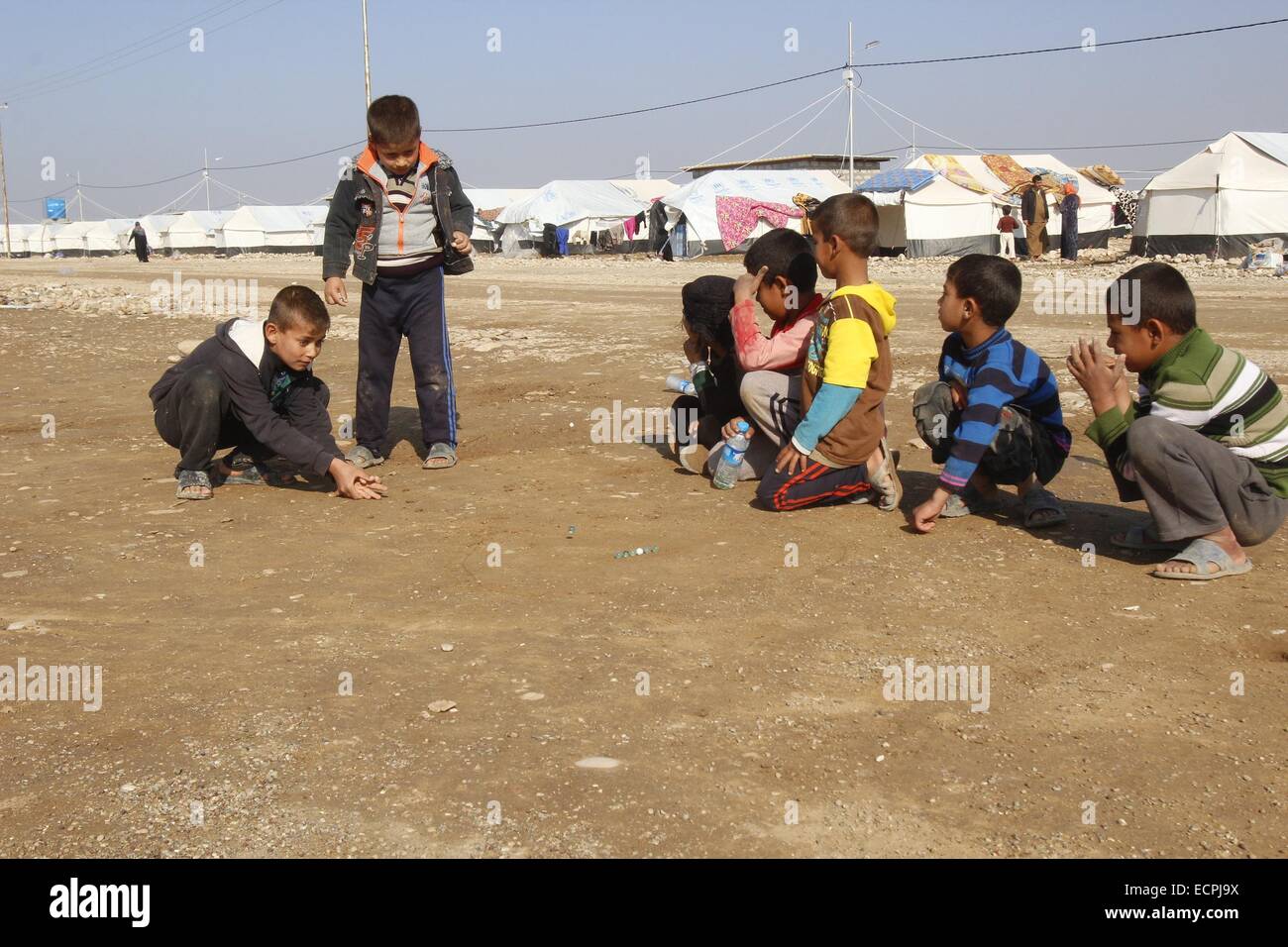 Kirkuk, Iraq. 17th Dec, 2014. Photo taken on Dec. 17, 2014 shows children playing outside their tents in the Ewa's Camp, 15 km northeast of the city of Kirkuk in northern Iraq. Credit:  Ako Zangana/Xinhua/Alamy Live News Stock Photo