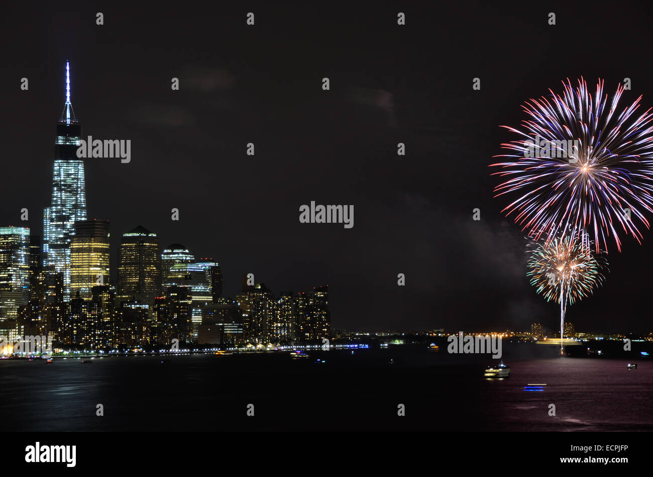 Fireworks celebrating New York City's 2014 Gay Pride Parade explode over lower Manhattan's Freedom Tower. Stock Photo