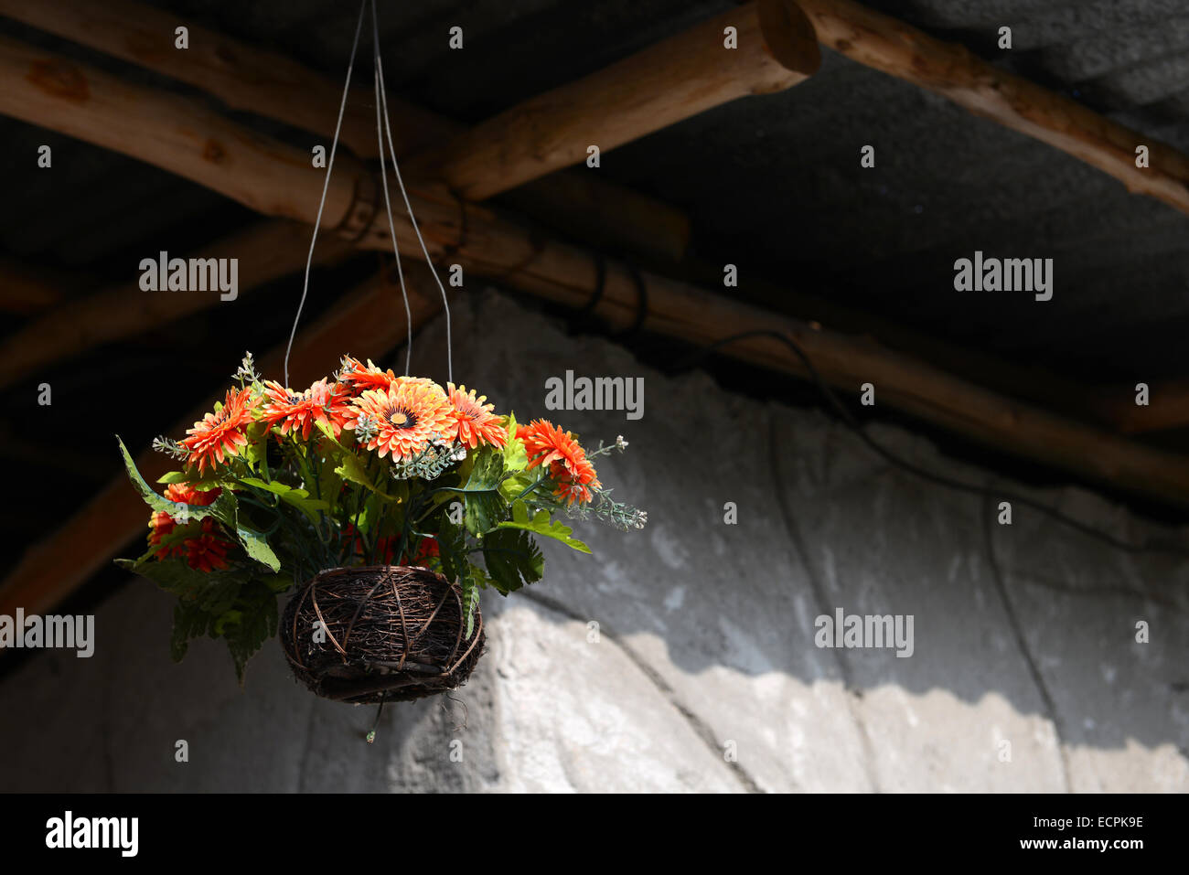 fake flower orange color in hanging basket for decorative home Stock Photo