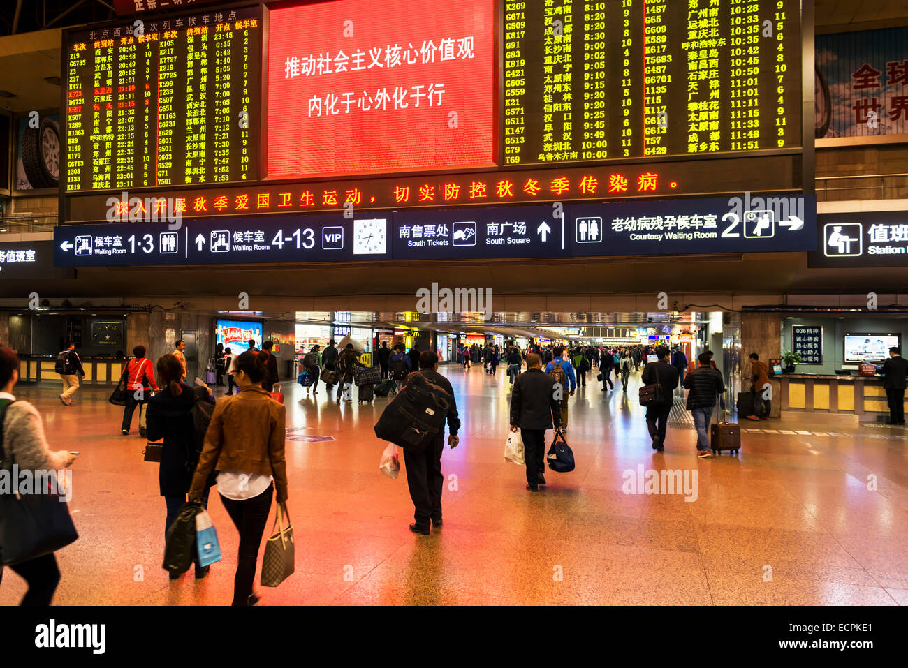 Beijing West train station interior full of people and a train departure board. Beijing, China 2014. Stock Photo
