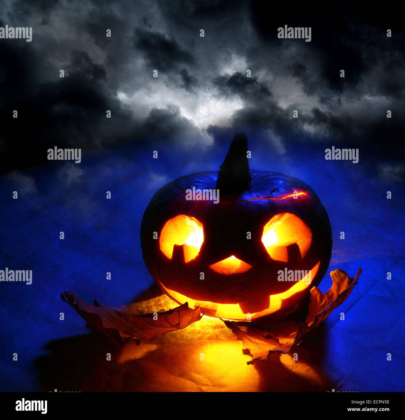 Funny halloween pumpkin with oak leaves at dark sky Stock Photo - Alamy