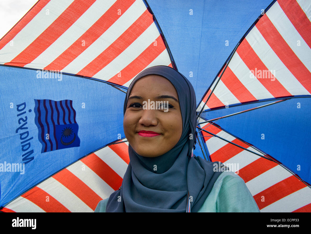 Smiling Malaysian gal under Malaysian umbrella, Kuala Lumpur Stock Photo