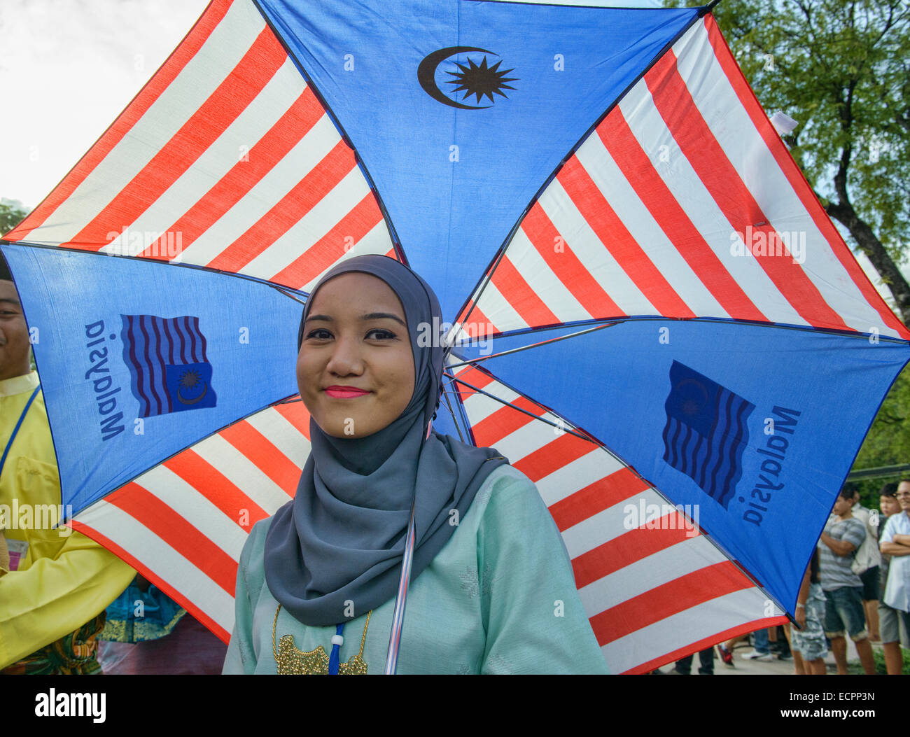 Smiling Malaysian gal under Malaysian umbrella, Kuala Lumpur Stock Photo