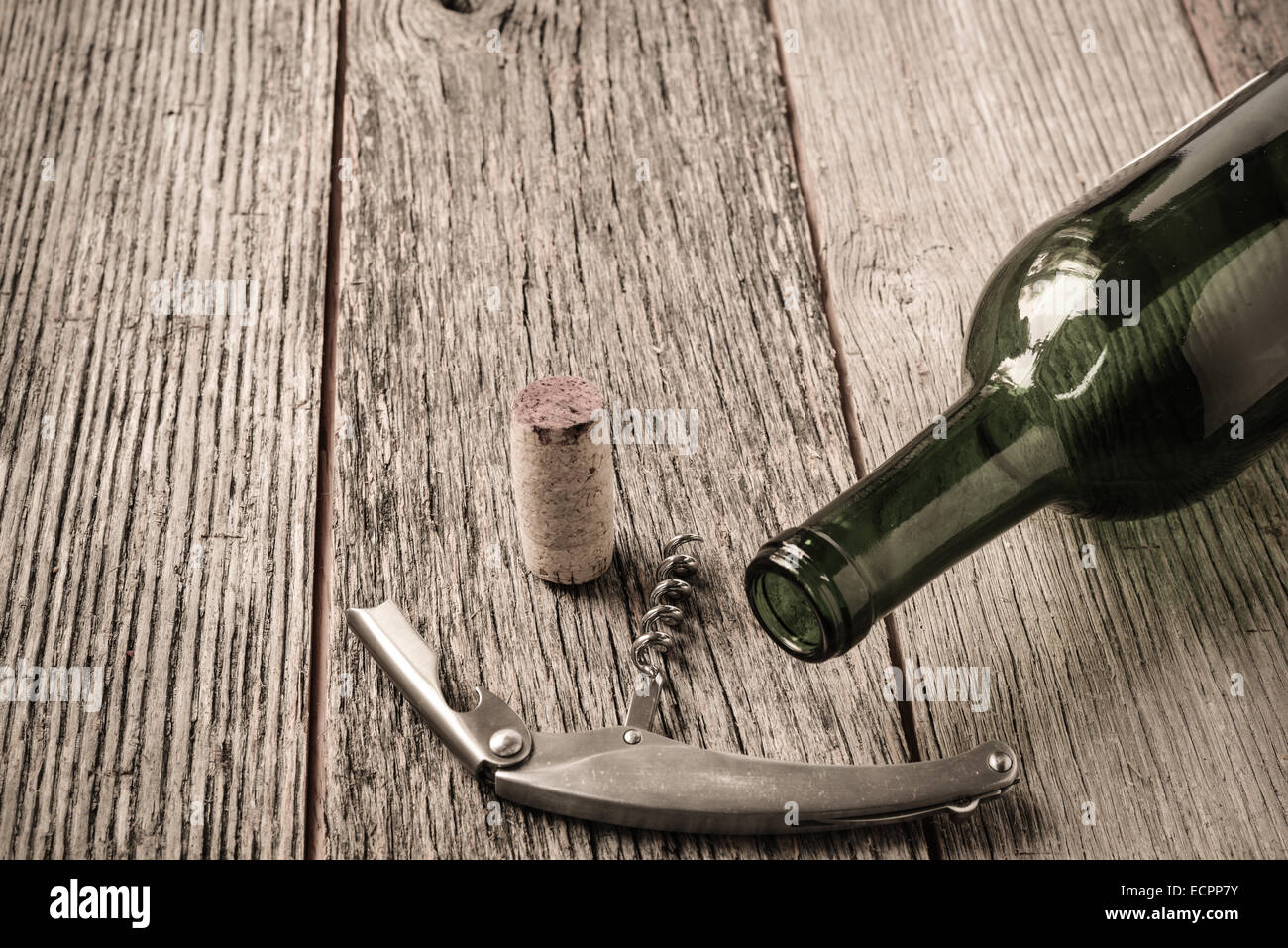 Green Wine Bottle and Cork with Red Wine and corkscrew Stock Photo