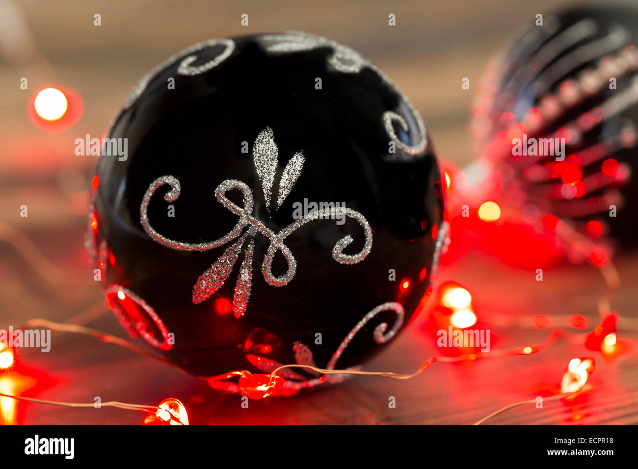 Black and silver Christmas baubles with red fairy lights Stock Photo