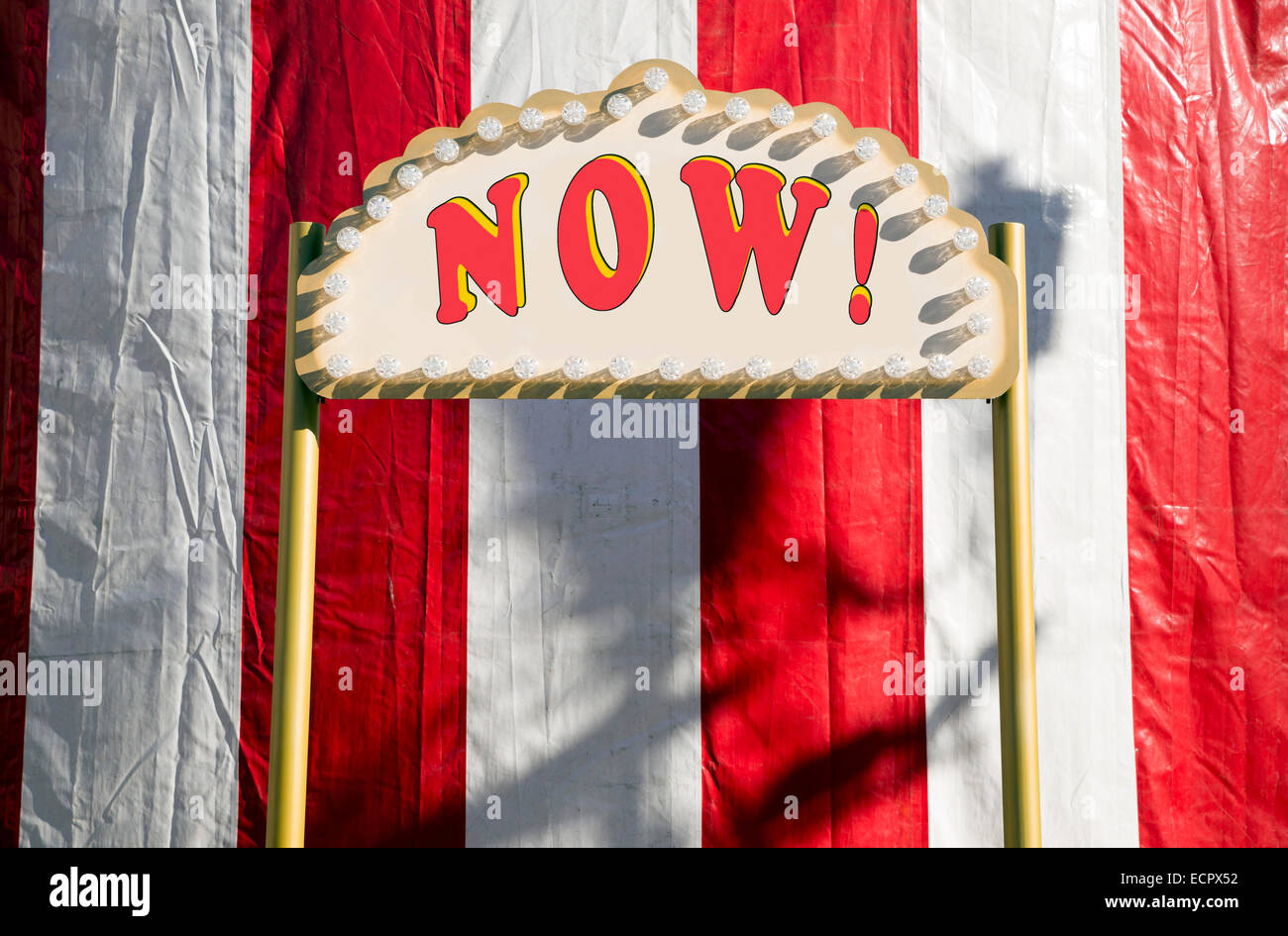 Now sign against red and white circus tent Stock Photo