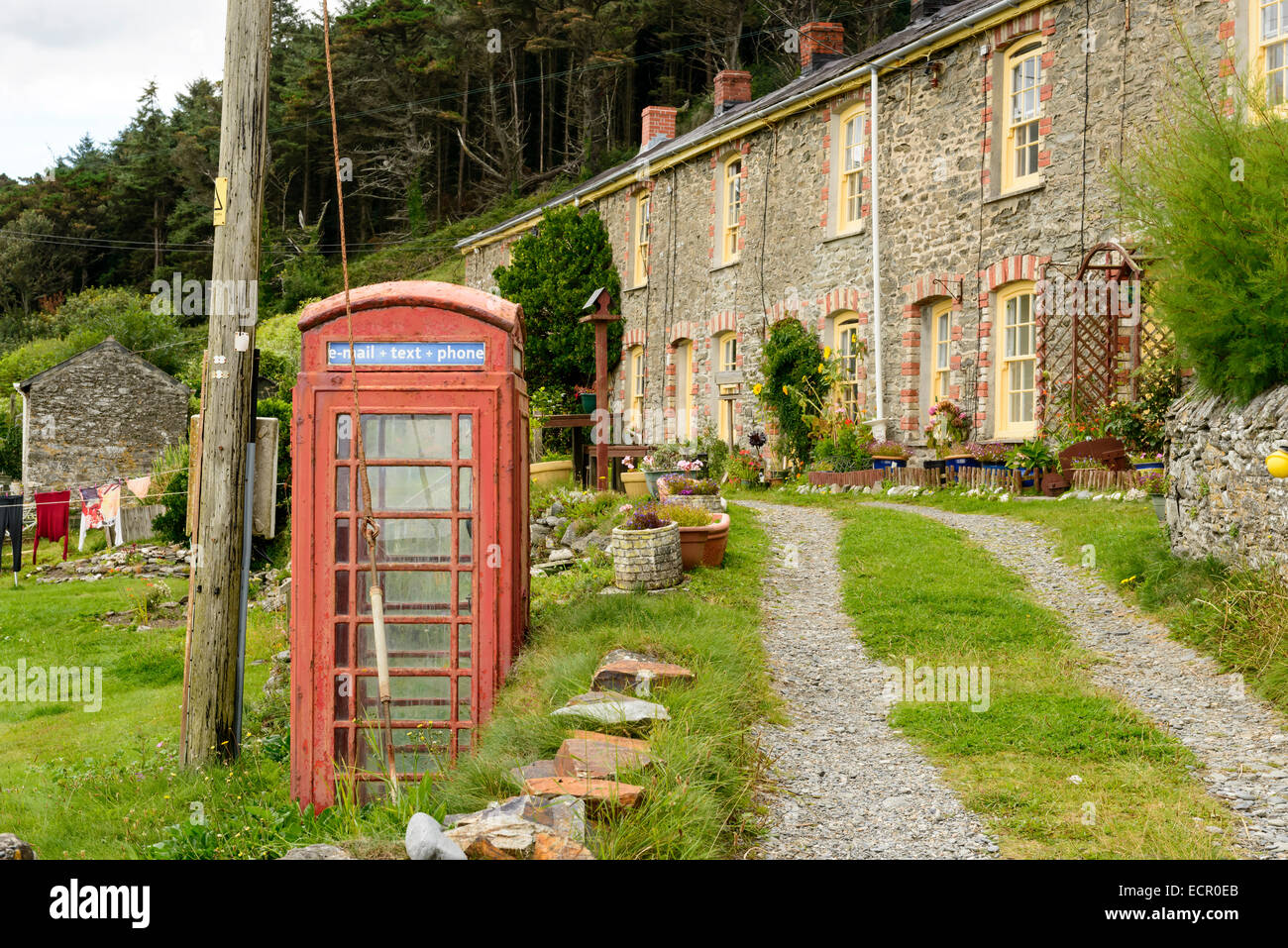 foreshortening  of old phone box and stone  terrace houses in front of sea in the small village in Cornwall Stock Photo