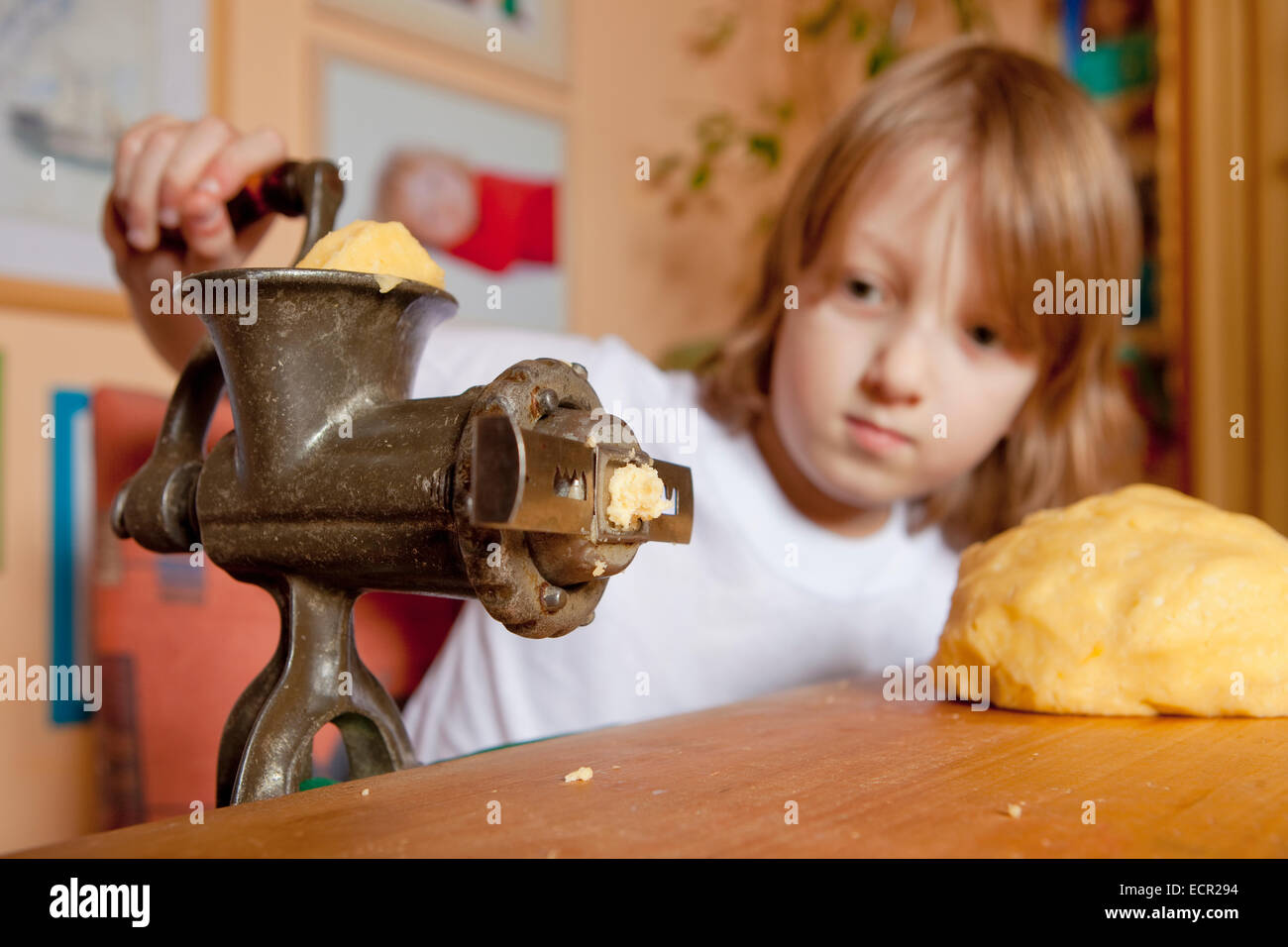 Boy Grinding Dough in the Kitchen Stock Photo
