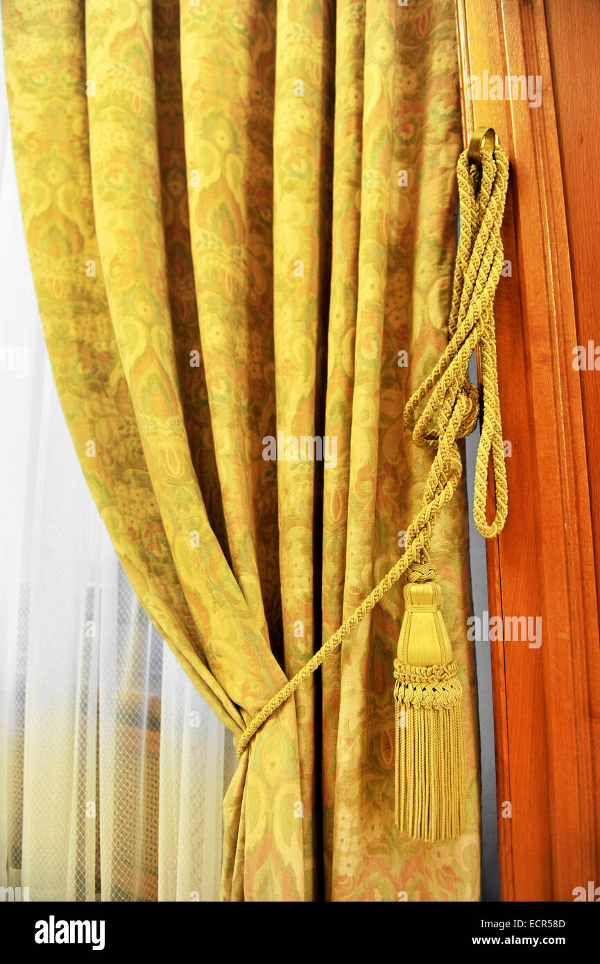 Detail shot with a yellow curtain decorative tassel Stock Photo