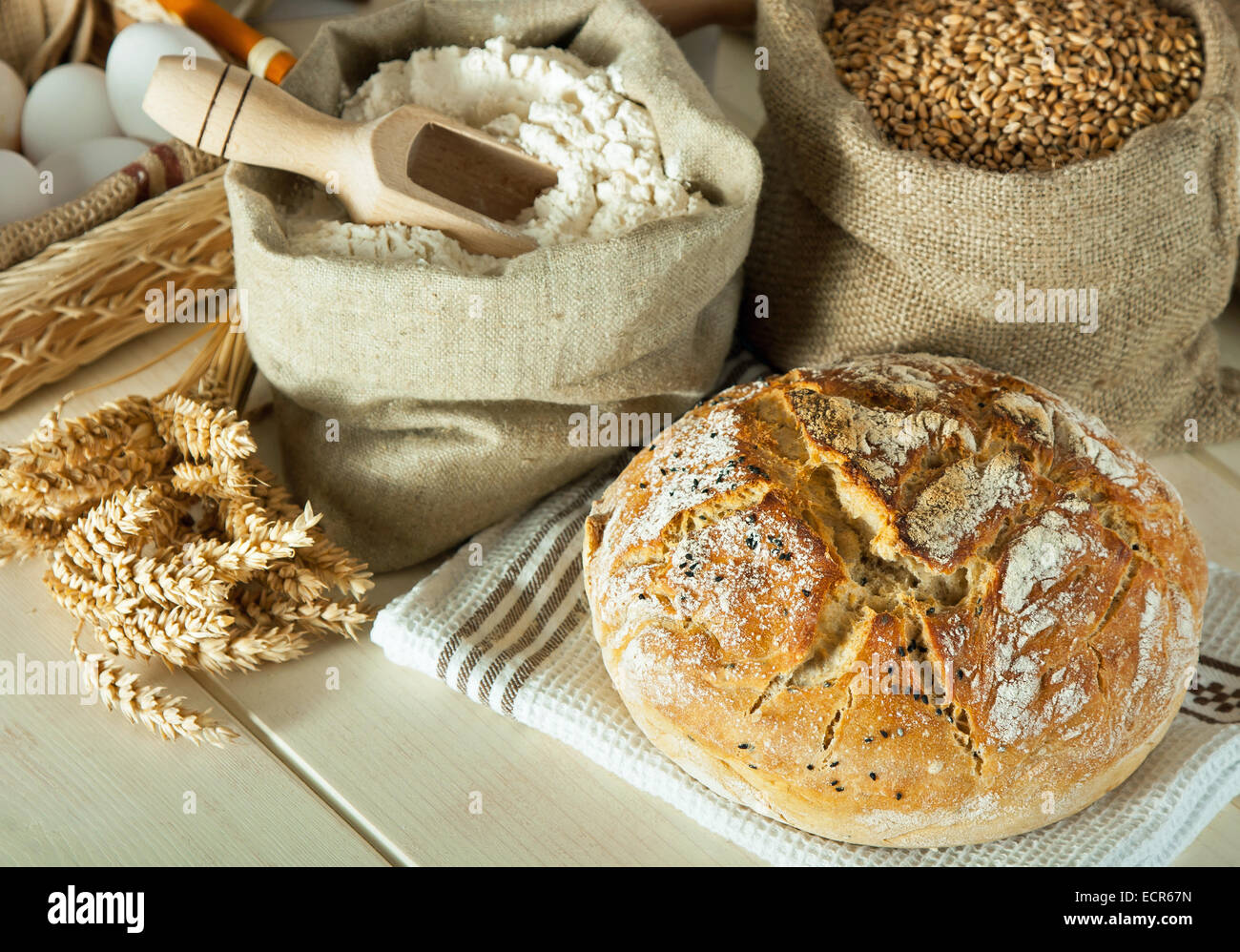 Homemade bread and wheat grain on table. Focus on bread Stock Photo