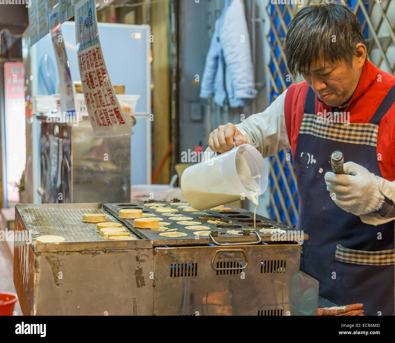 TAIPEI CITY, TAIPEI, TAIWAN. DECEMBER 17, 2014.  Vendor making cartwheel pies at Shida night market Stock Photo