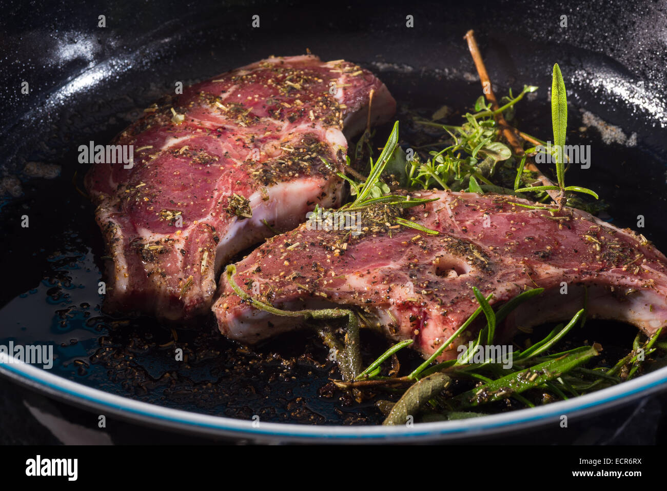 Lamb chops with rosemary roasted in a pan flesh food eating animals slice of frying grilling stewing fresh expensive exclusive Stock Photo