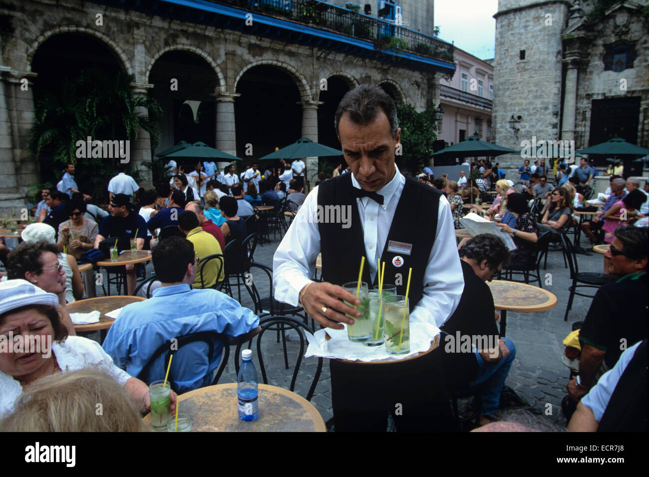 Waiter at El Patio Restaurant in Plaze de la Catedral serving Mojitos, Old Havana, Cuba Stock Photo