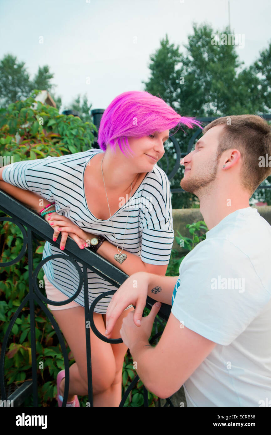 Boy and girl standing near a railing and talking Stock Photo