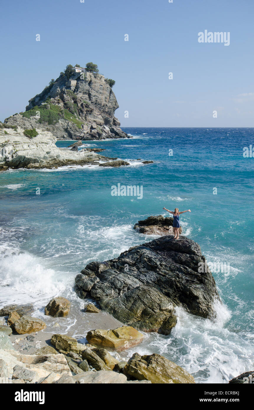 Woman on beach atop rock in front of Mamma Mia chapel, Agios Ioannis,  Skopelos, Greece. October Stock Photo - Alamy