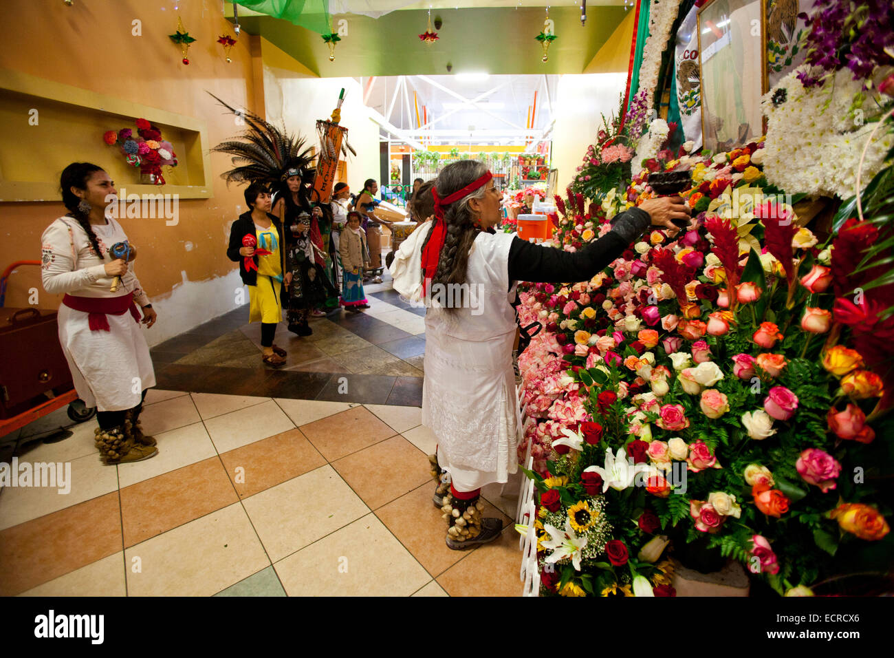 Aztec dancers bless the Flower vendors in the Flower Mart, downtown Los Angeles, California, United States of America Stock Photo