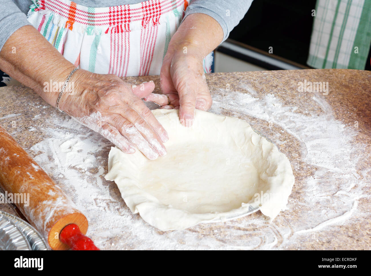 Senior woman hands preparing pie crust, baking in the kitchen Stock Photo