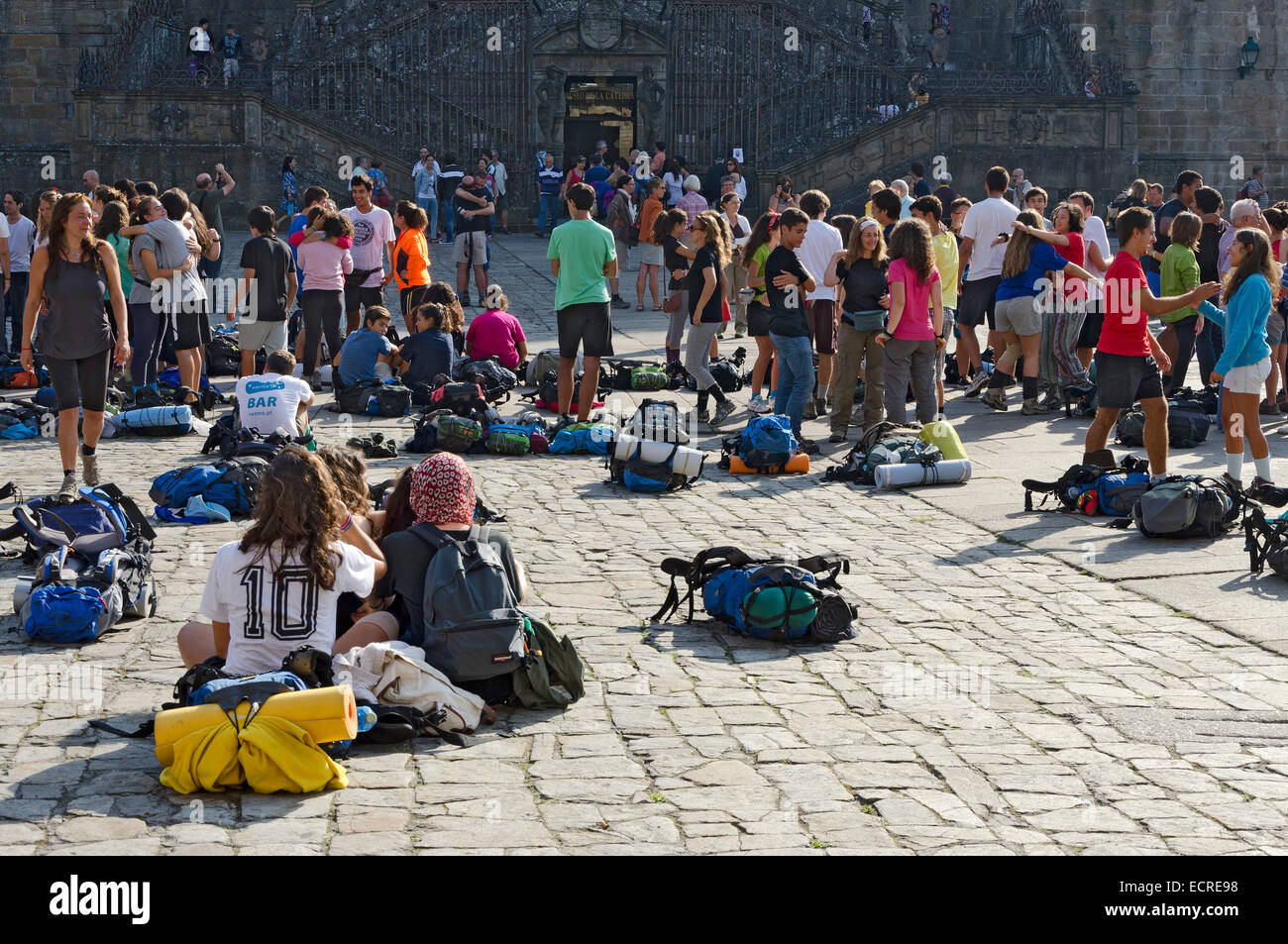 SANTIAGO DE COMPOSTELA, SPAIN – SEPTEMBER 8, 2012: Pilgrims rest on end the Camino de Santiago in the Obradoiro Square after rea Stock Photo