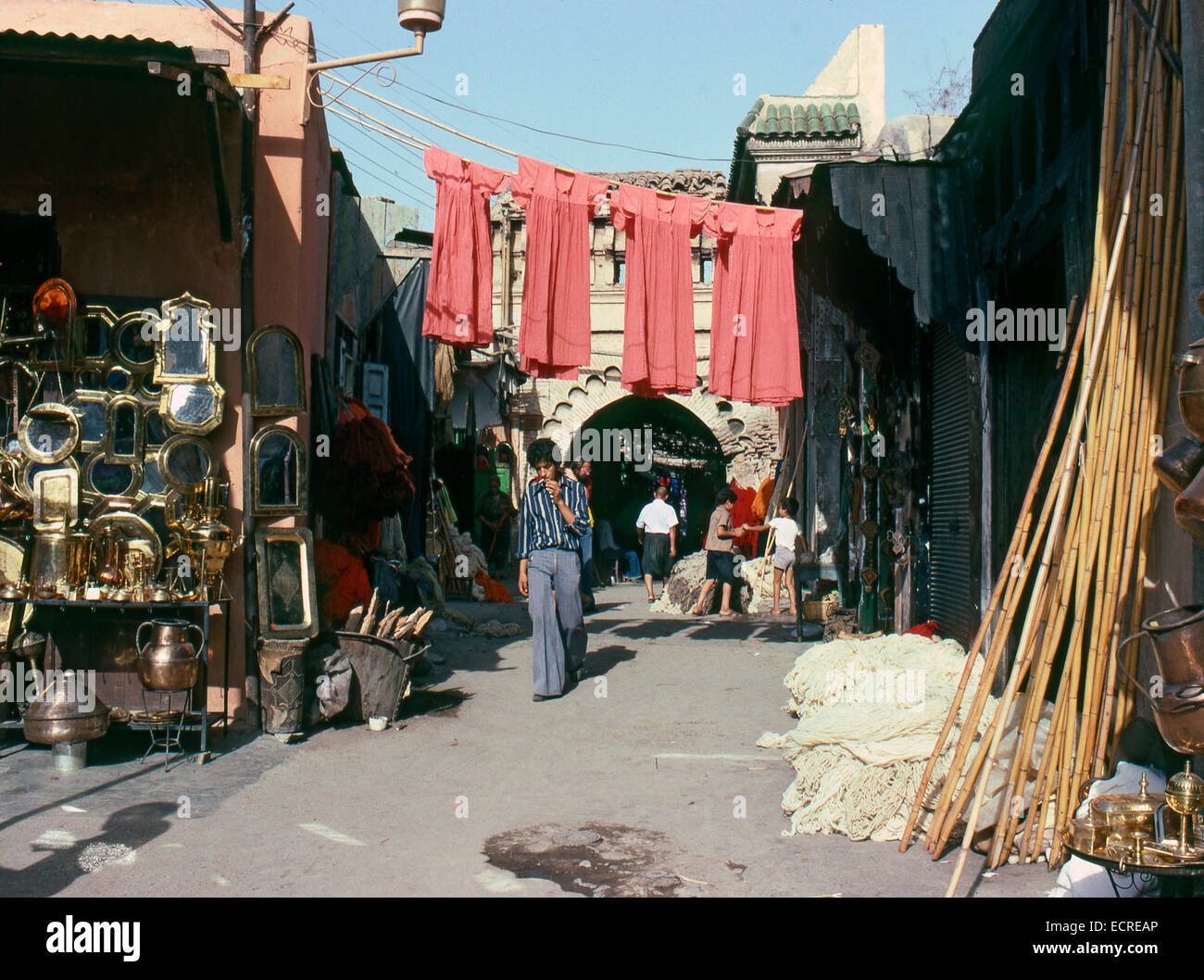 MARRAKECH, MOROCCO – AUGUST, 1979: People walking down a shopping street in the medina of a North African city on August, 1979 i Stock Photo