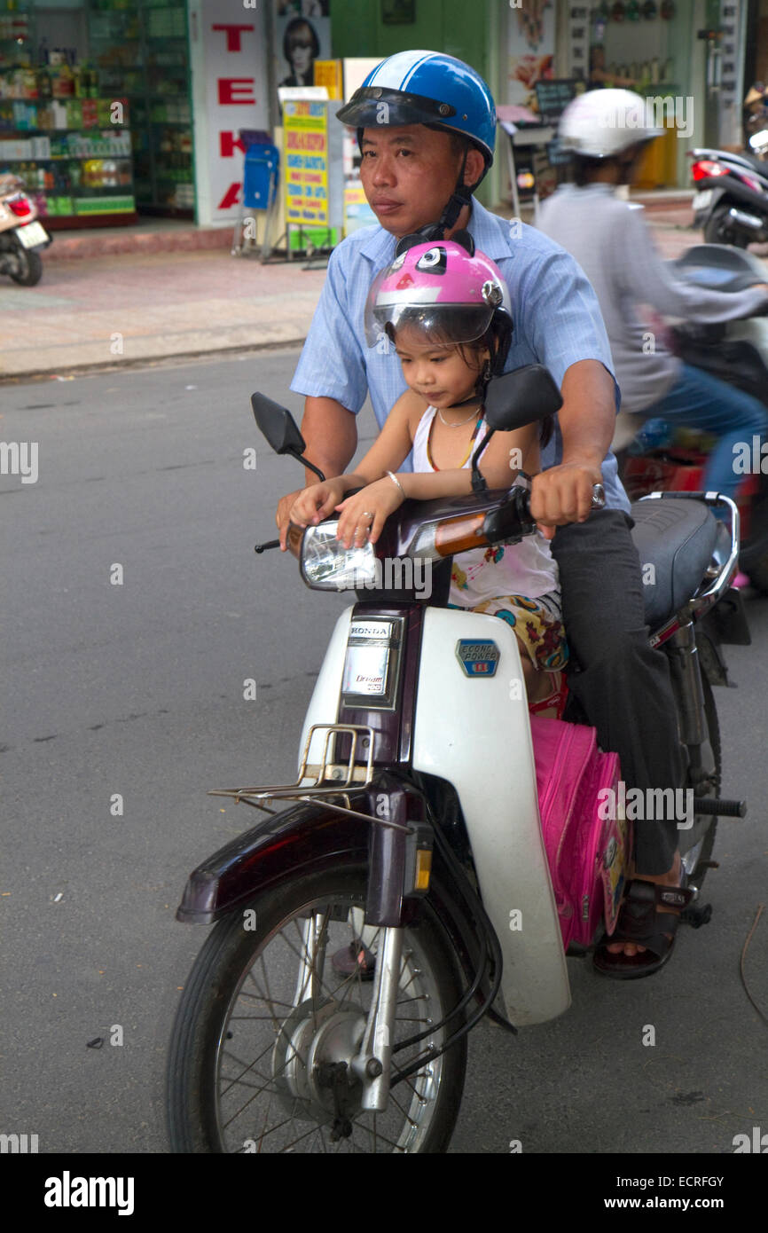 Father and child riding a motor scooter together in Nha Trang, Vietnam. Stock Photo
