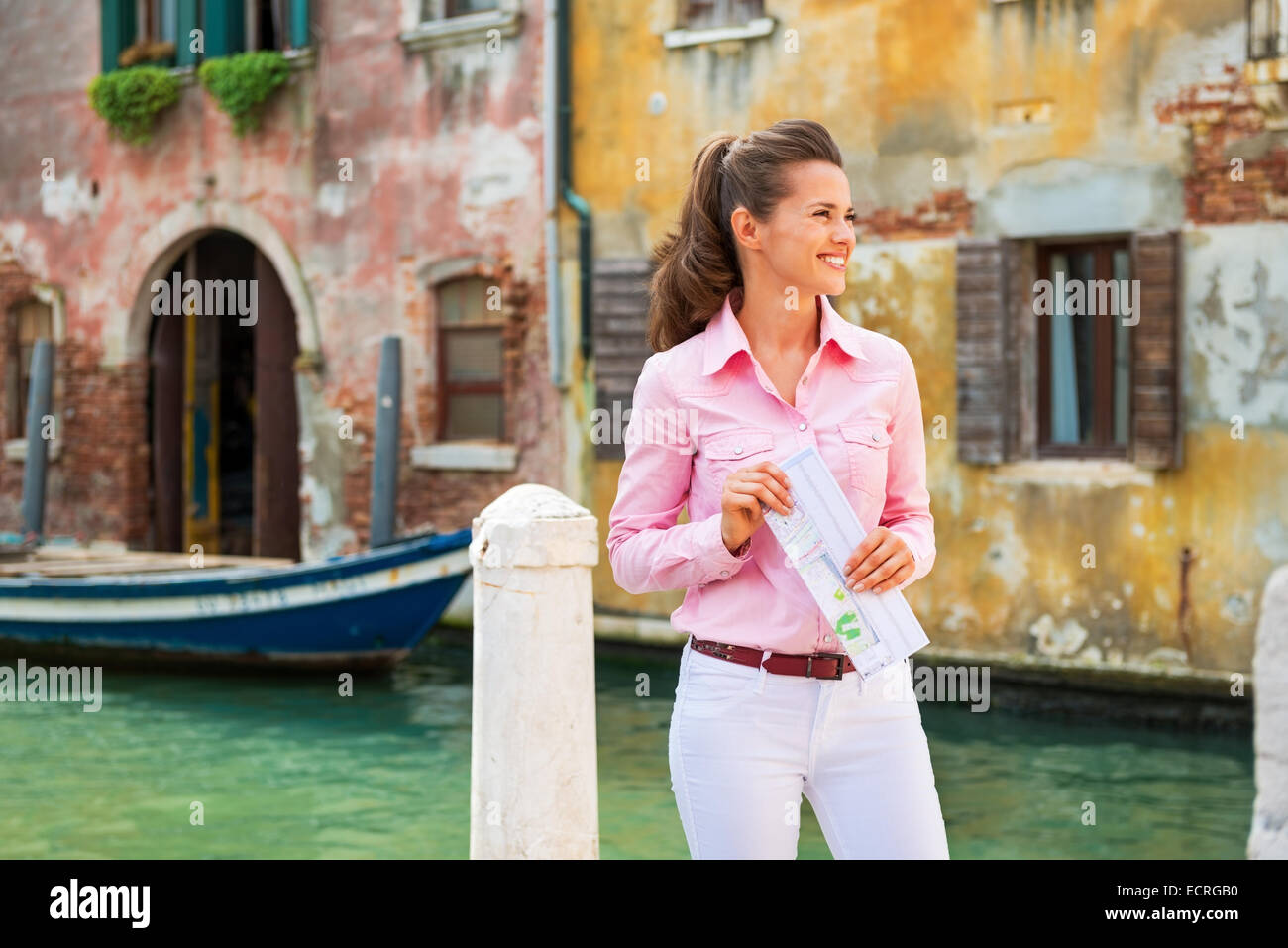 Happy young woman with map in venice, italy Stock Photo