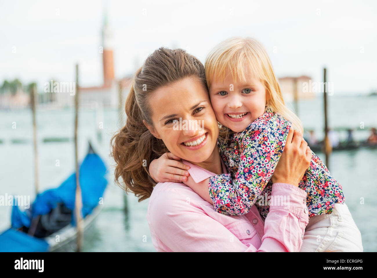 Portrait of happy mother and baby on grand canal embankment in venice, italy Stock Photo