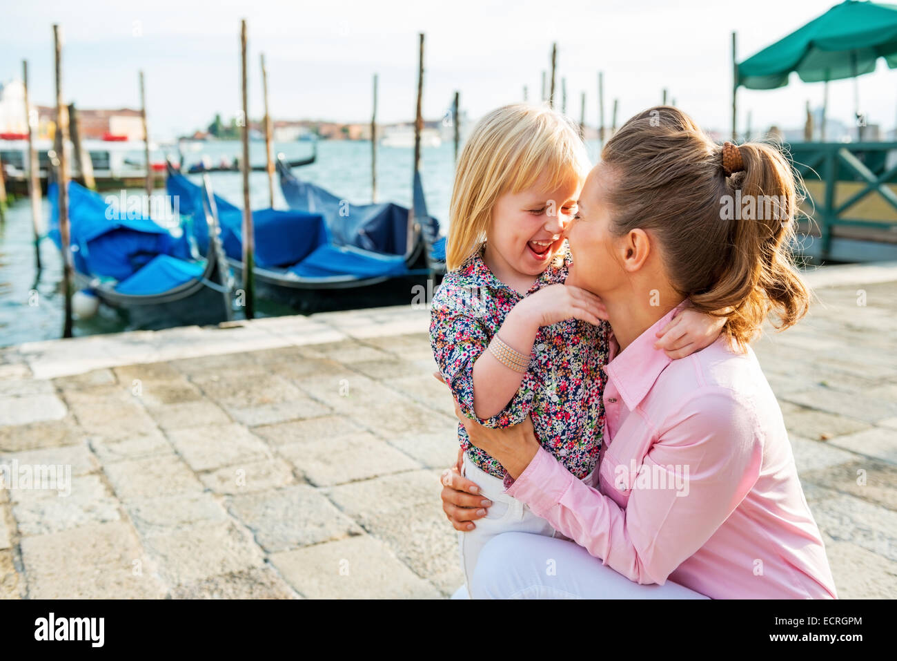 Portrait of happy mother and baby on grand canal embankment in venice, italy Stock Photo