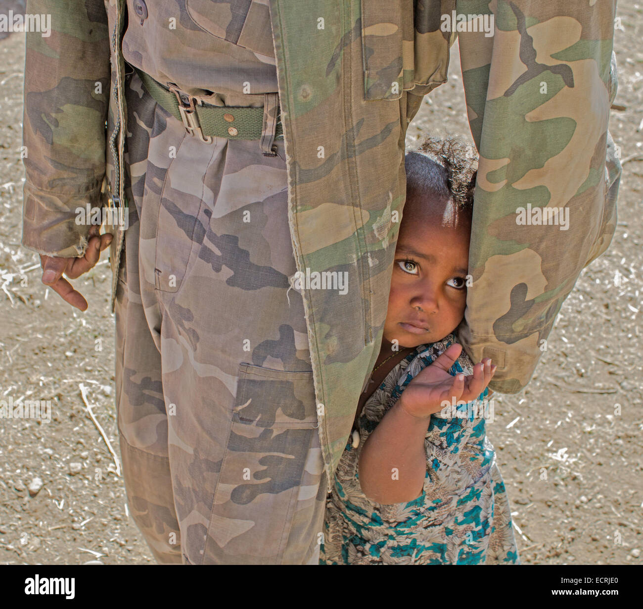 African child hiding behind a guard Stock Photo - Alamy