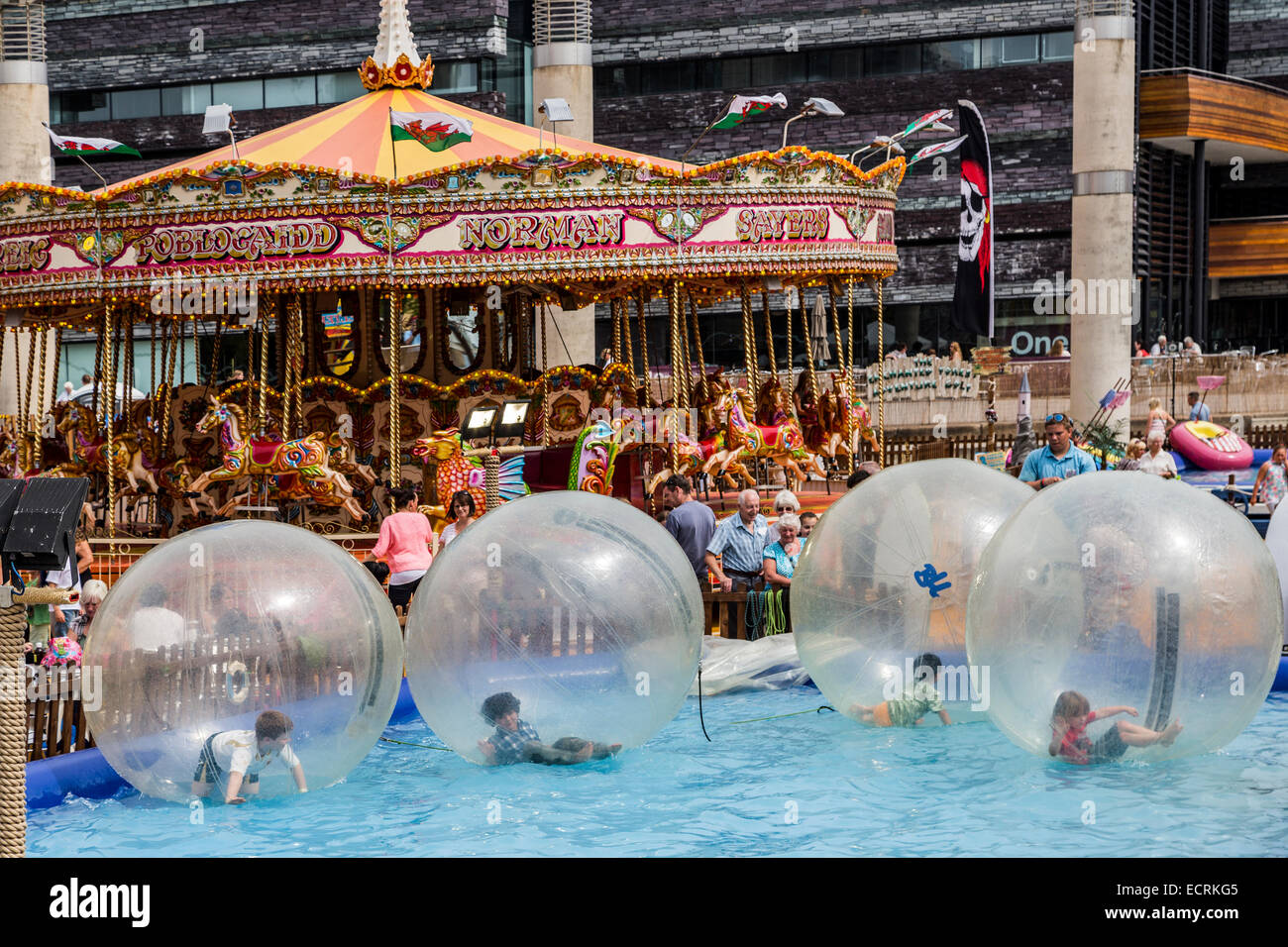 Children playing in floating balls at fun fair, Cardiff Bay, Wales, UK Stock Photo