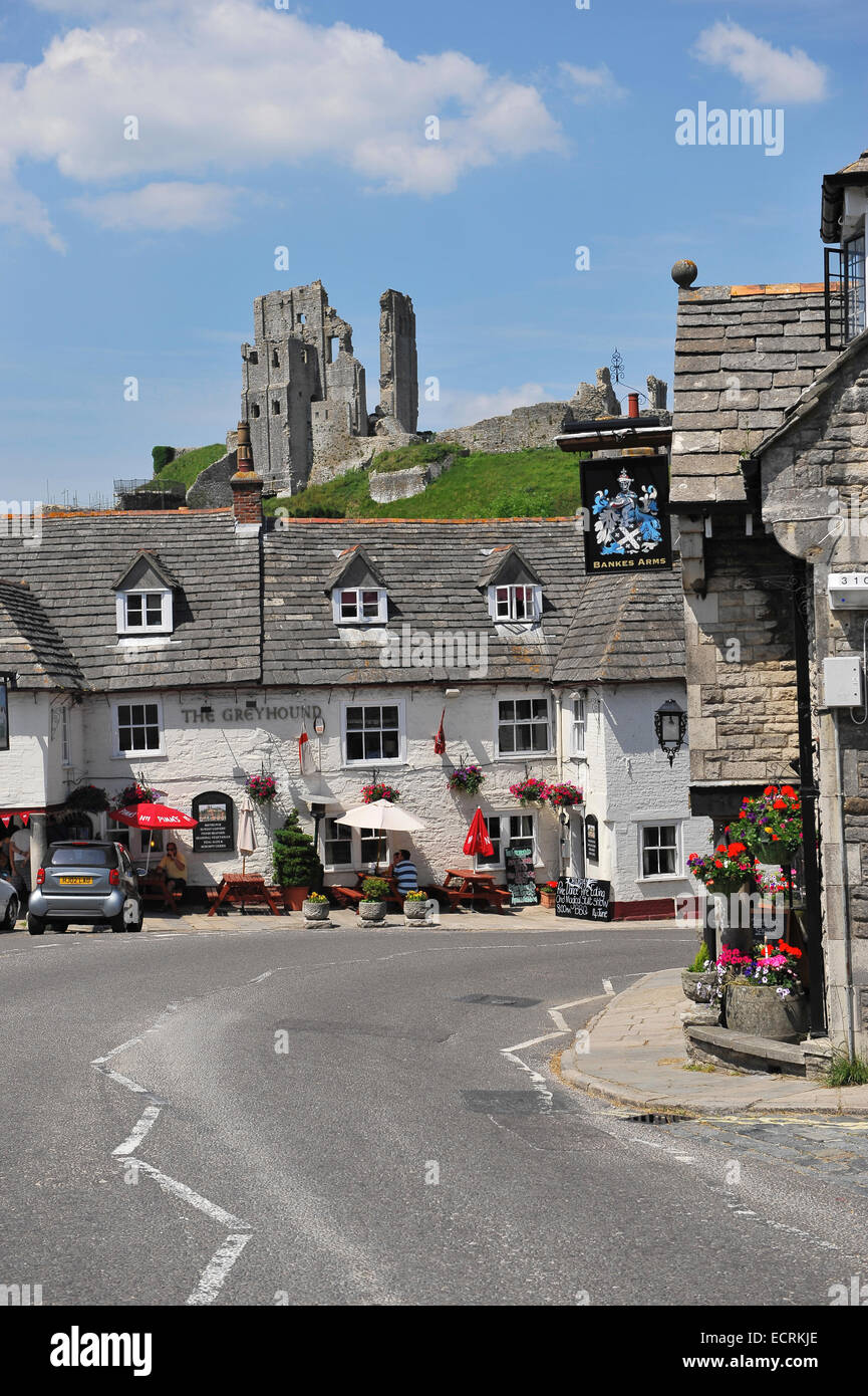 A village scene in Corfe Castle Village, Dorset, England, United Kingdom, with Corfe Castle in the background. Stock Photo