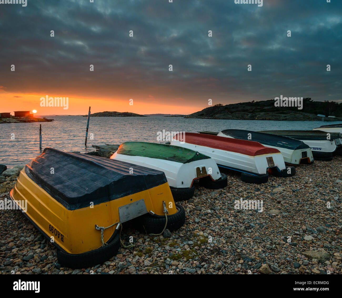 Colourful rowboats on the beach at sunset Stock Photo