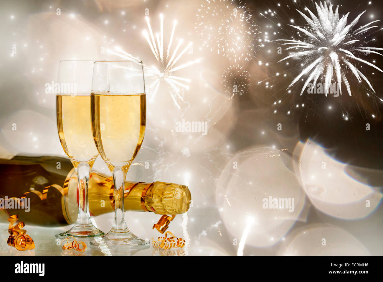 Glasses with champagne and bottle over fireworks and sparkling holiday background Stock Photo