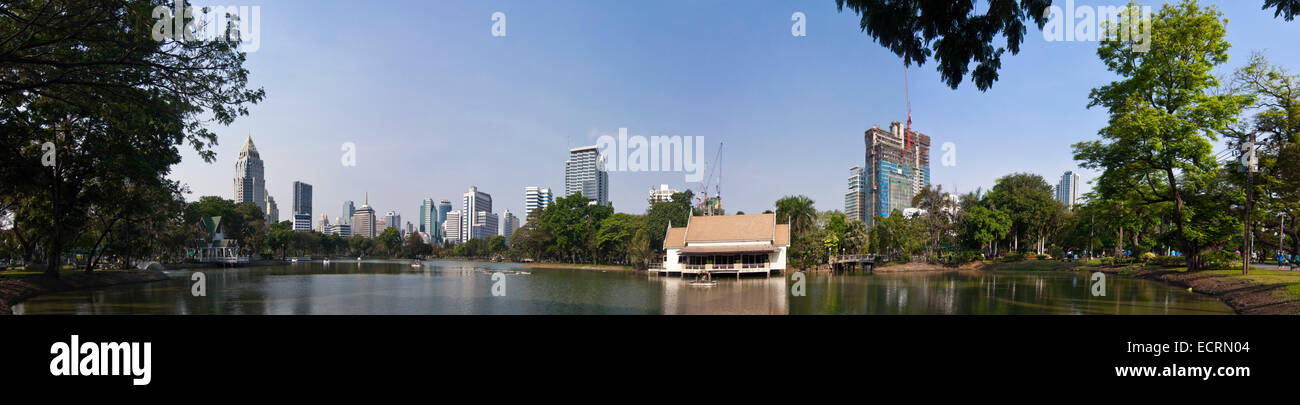 Horizontal panoramic (3 picture stitch) view across the lake towards Silom-Sathorn CBD (central Business district) in Bangkok. Stock Photo