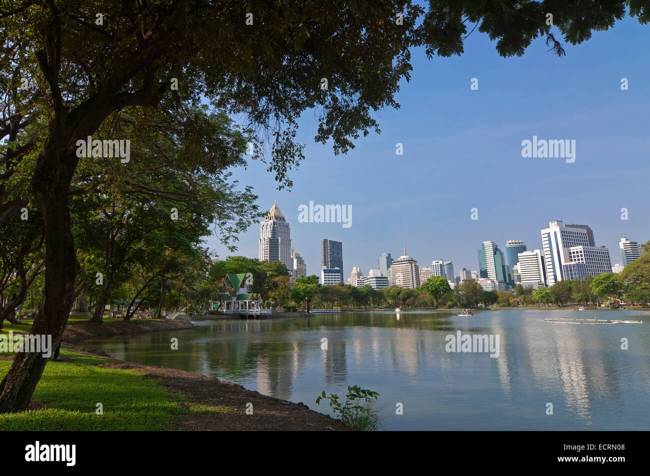 Horizontal panoramic view towards the Silom-Sathorn CBD (central Business district) across the lake at Lumphini park in Bangkok. Stock Photo